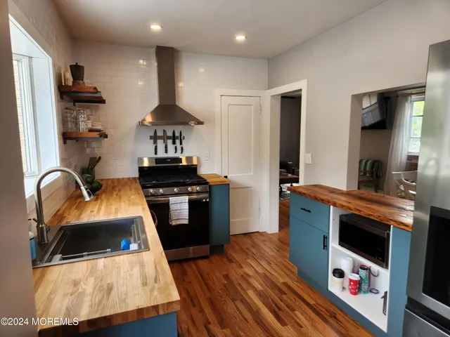 a kitchen with stainless steel appliances granite countertop a stove a sink and a refrigerator