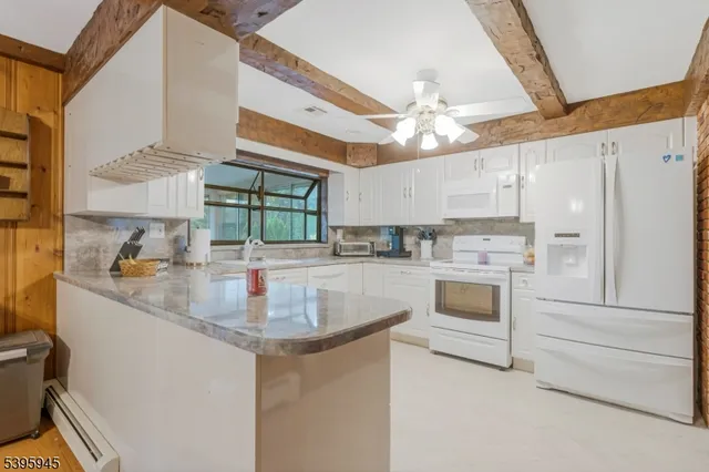 a kitchen with white cabinets and white appliances