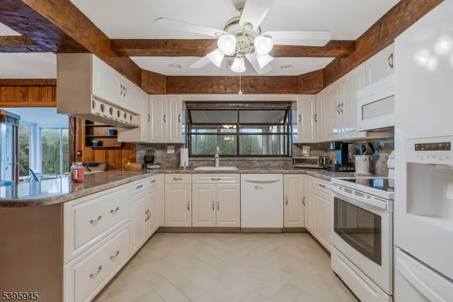 a kitchen with white cabinets and white appliances