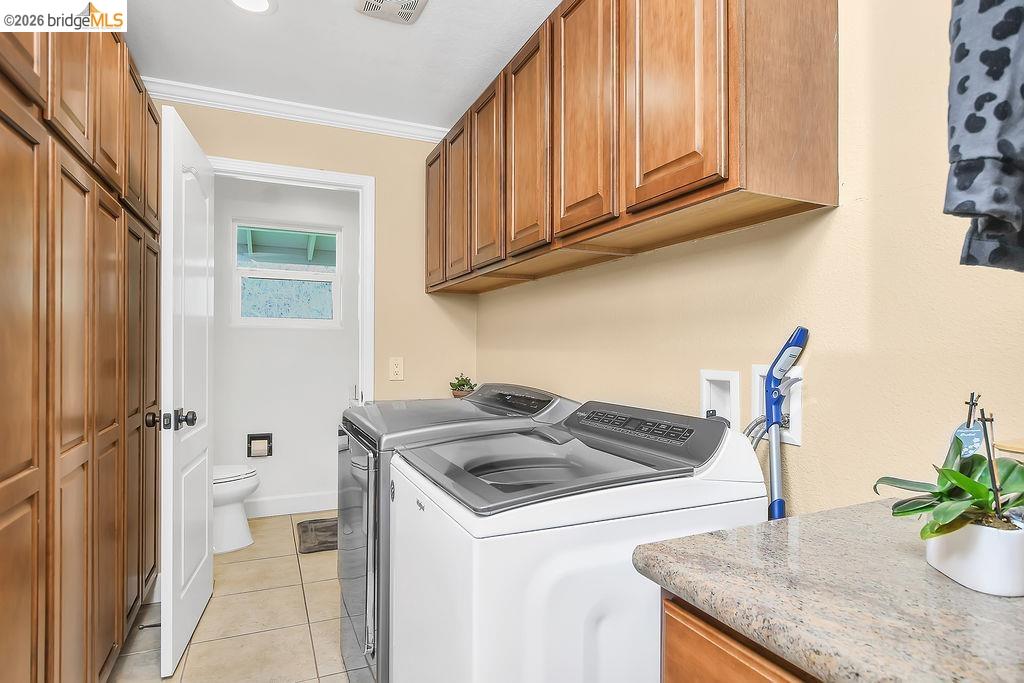 4190 Brown Road Oakley, CA 94561 - Photo 16 of 33 Laundry area featuring separate washer and dryer, light tile patterned flooring, cabinet space, and crown molding