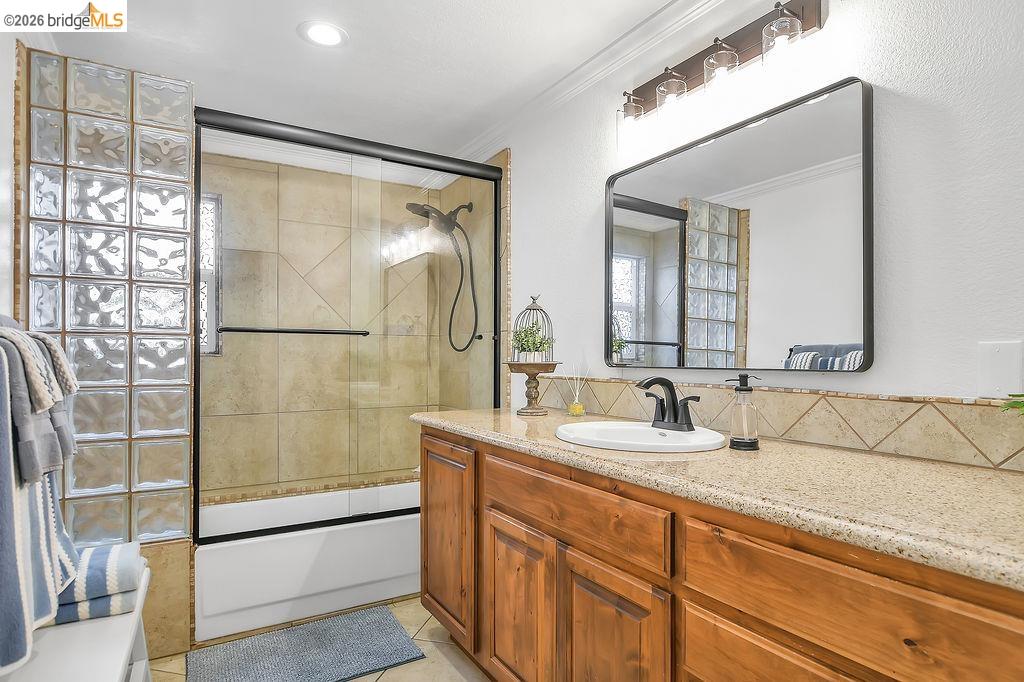4190 Brown Road Oakley, CA 94561 - Photo 21 of 33 Bathroom featuring vanity, combined bath / shower with glass door, ornamental molding, and light tile patterned floors