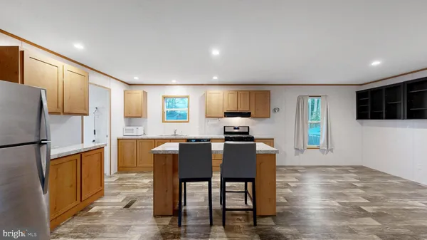 a kitchen with granite countertop a refrigerator and microwave