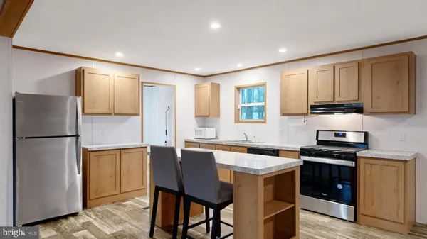 a kitchen with a sink a stove a refrigerator a center island and a window