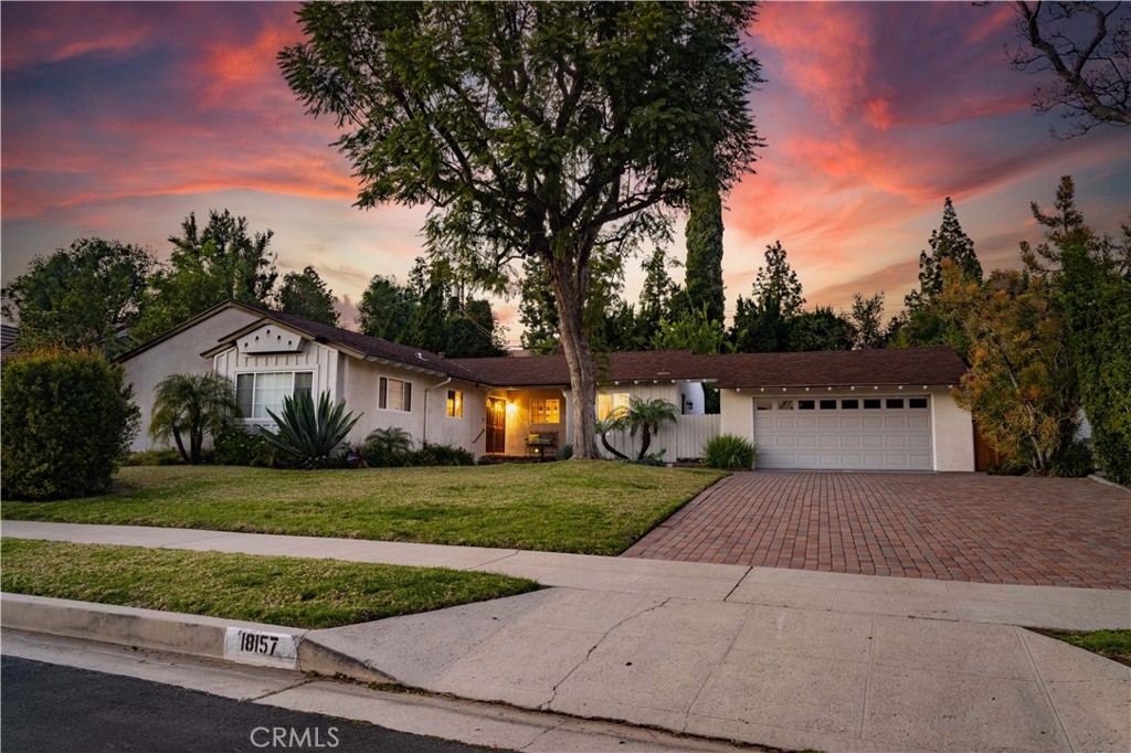 a front view of a house with a yard and trees