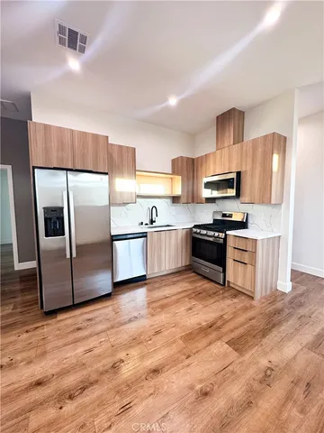 a kitchen with granite countertop a refrigerator and a stove top oven