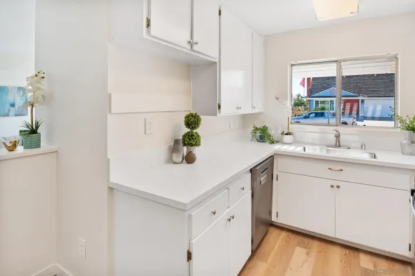 a kitchen with stainless steel appliances cabinets and wooden floor
