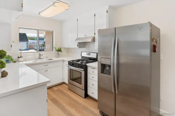 a kitchen with stainless steel appliances a refrigerator sink and cabinets