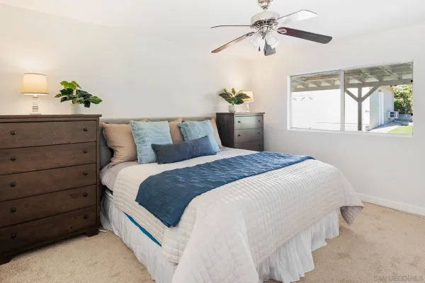 a bedroom with a bed and a chandelier fan