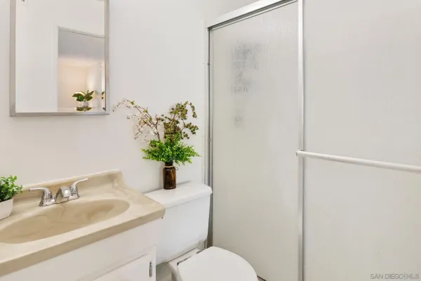 a bathroom with a sink mirror and toilet