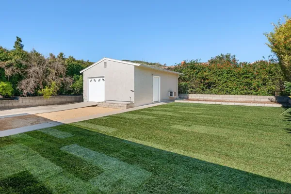 a view of a white house with a big yard
