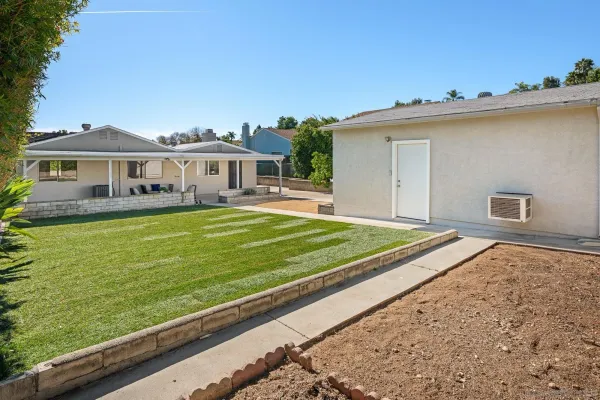 a view of a house with a big yard and potted plants