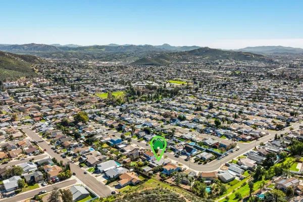 an aerial view of residential houses with outdoor space and trees