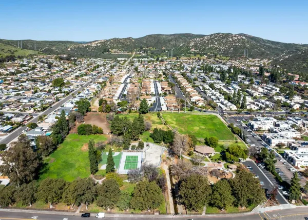 an aerial view of residential houses with outdoor space and trees