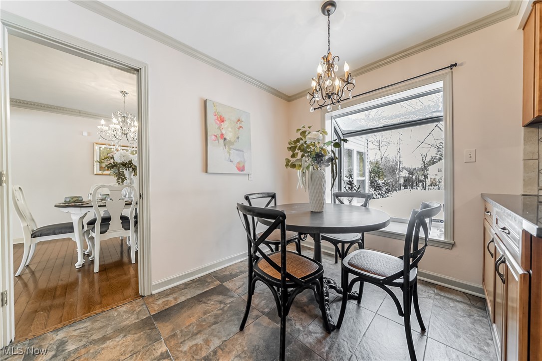 Dining space with ornamental molding and a chandelier