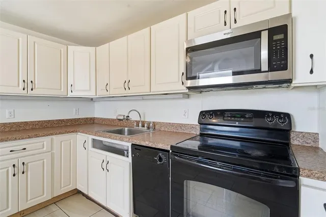 a kitchen with granite countertop white cabinets and stainless steel appliances