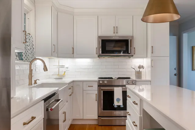 a kitchen with stainless steel appliances granite countertop a sink stove and microwave