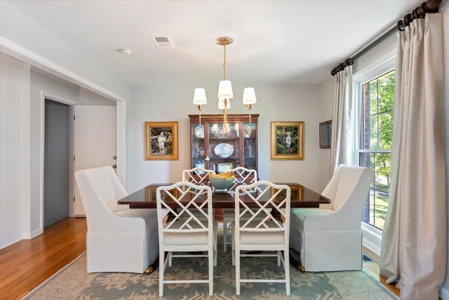 a dining room with furniture a chandelier and wooden floor