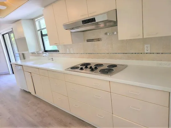a kitchen with granite countertop white cabinets and white appliances