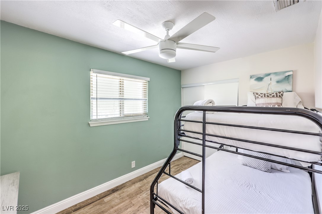 1553 Dorothy Avenue, Unit 4 Las Vegas, NV 89119 - Photo 17 of 36 Bedroom with wood finished floors, ceiling fan, and a textured ceiling
