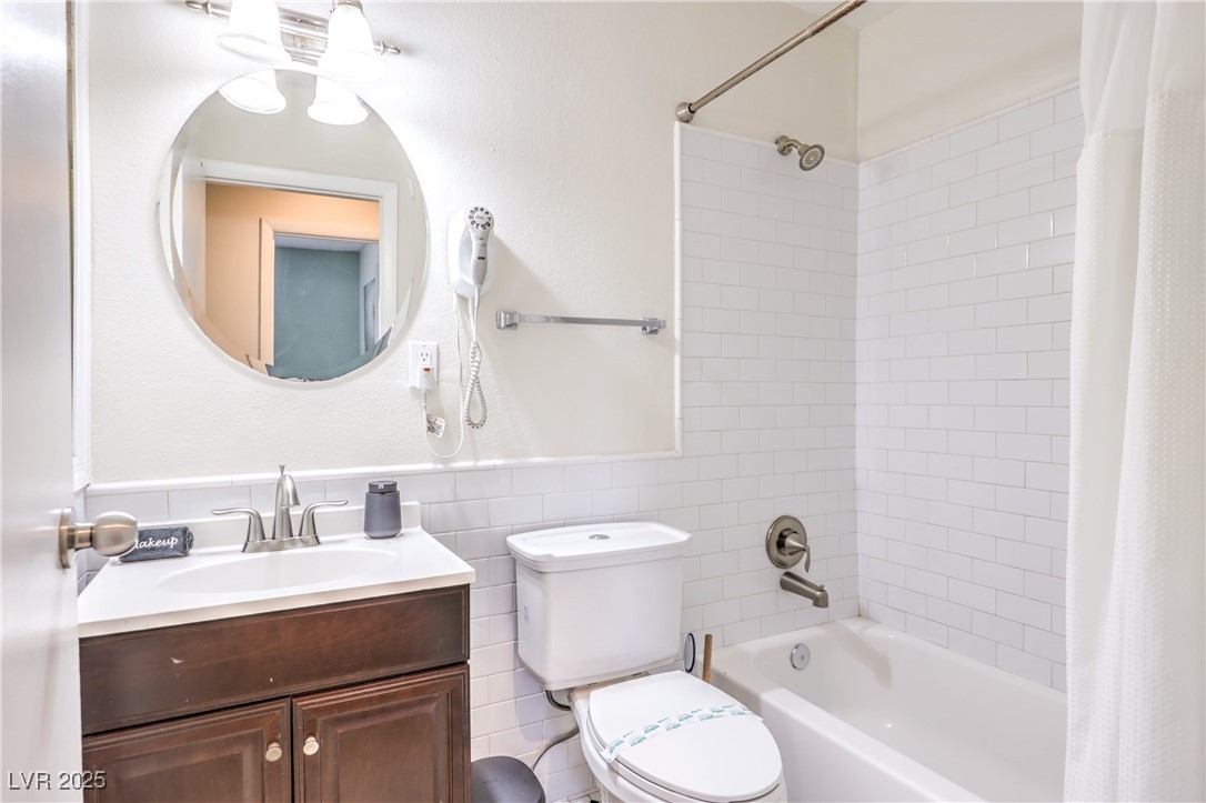 1553 Dorothy Avenue, Unit 4 Las Vegas, NV 89119 - Photo 19 of 36 Full bath featuring shower / bathtub combination with curtain, vanity, and tile walls