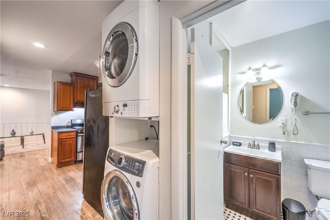 1553 Dorothy Avenue, Unit 4 Las Vegas, NV 89119 - Photo 20 of 36 Laundry area featuring wainscoting, stacked washer and clothes dryer, recessed lighting, and light wood-style flooring