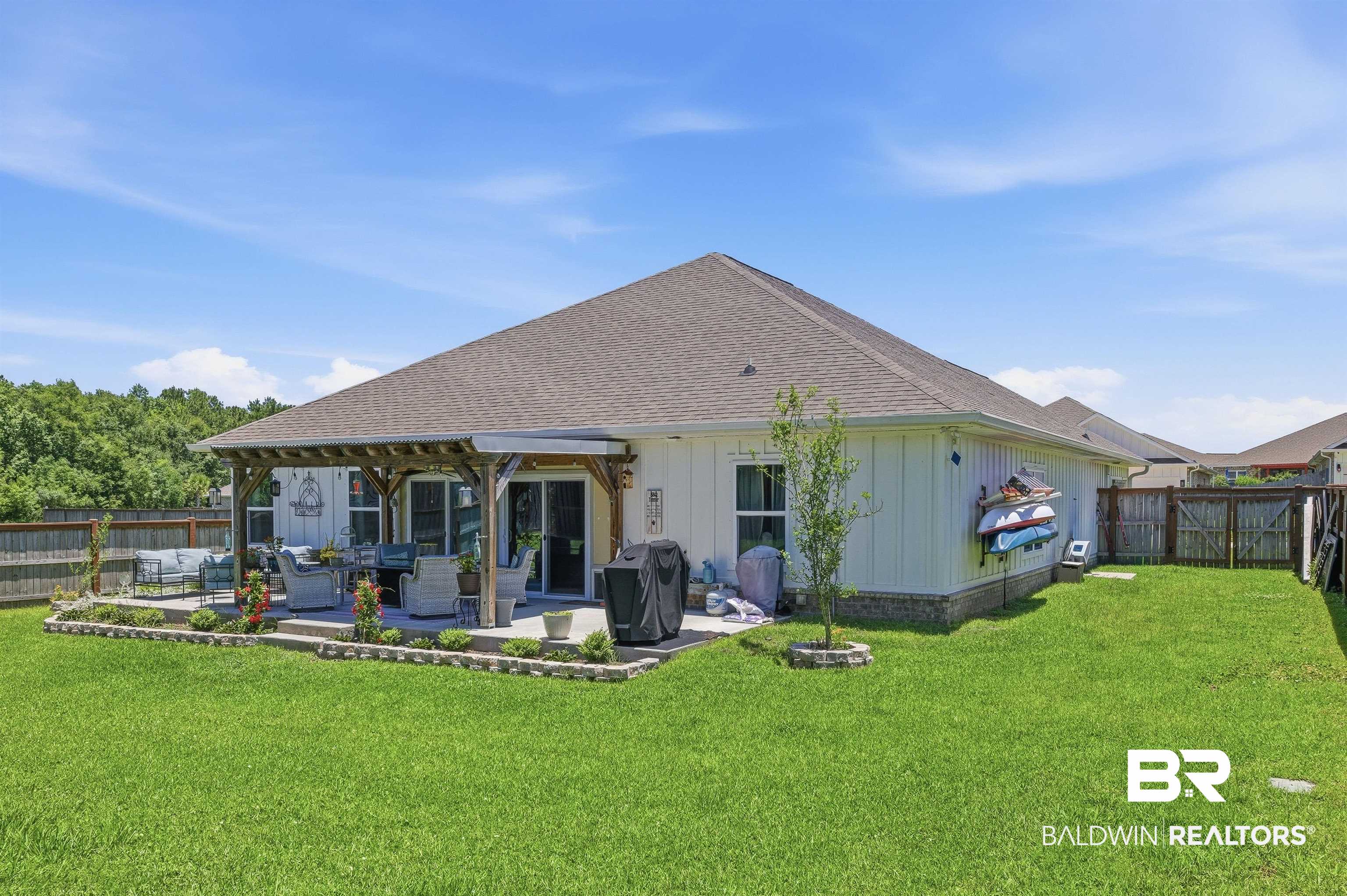 8735 Bronze Lane Foley, AL 36535 - Photo 46 of 58 Rear exterior featuring a covered patio with a pergola, a concrete patio, and sliding glass doors