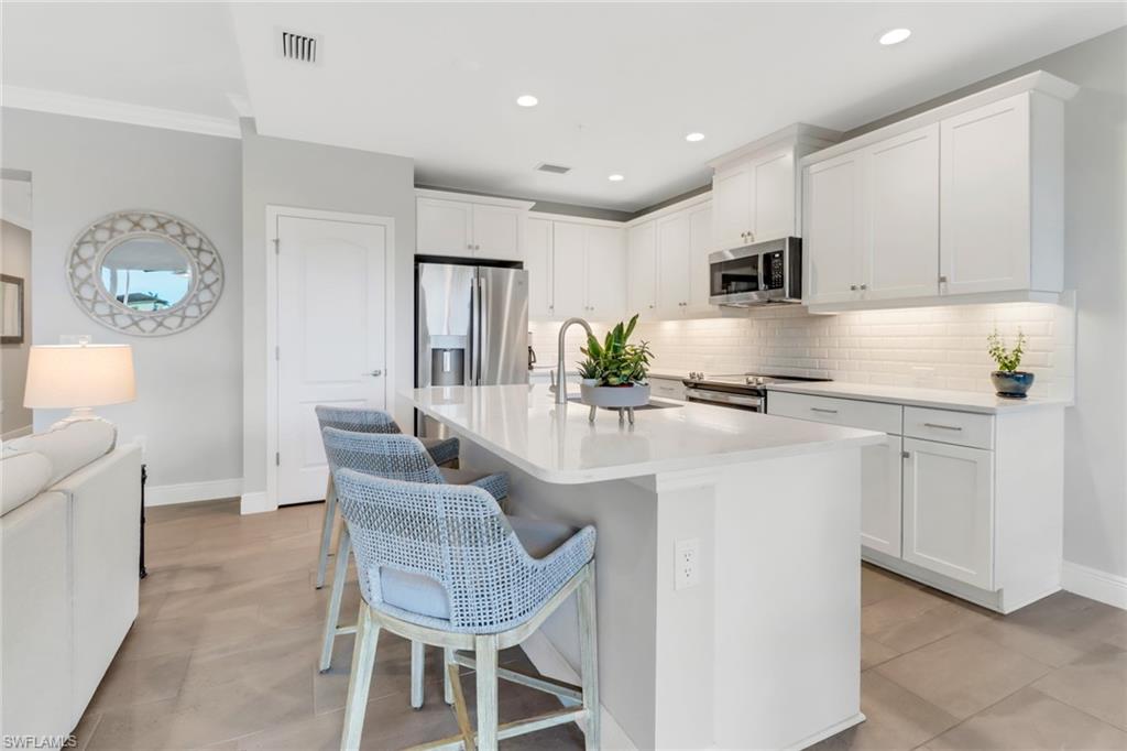 a kitchen with kitchen island granite countertop a counter space dining table and stainless steel appliances