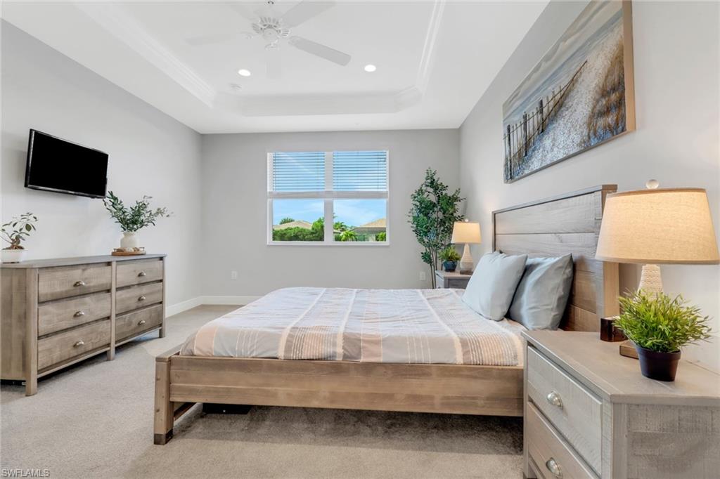 2295 Sawyers Hill Road, Unit 1002 Naples, FL 34120 - Photo 15 of 41 a bedroom with a bed and a flat screen tv