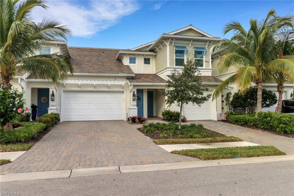 2295 Sawyers Hill Road, Unit 1002 Naples, FL 34120 - Photo 24 of 41 a front view of a house with a yard and garage