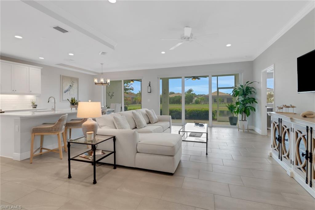 2295 Sawyers Hill Road, Unit 1002 Naples, FL 34120 - Photo 3 of 41 a living room with furniture and a flat screen tv