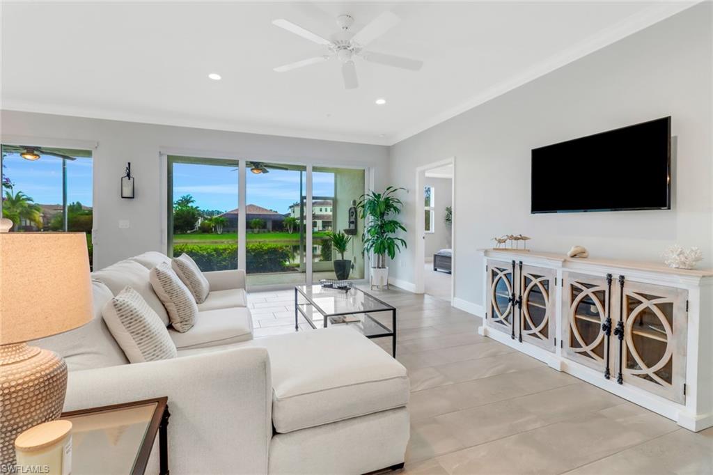 2295 Sawyers Hill Road, Unit 1002 Naples, FL 34120 - Photo 4 of 41 a living room with furniture a flat screen tv and a large window