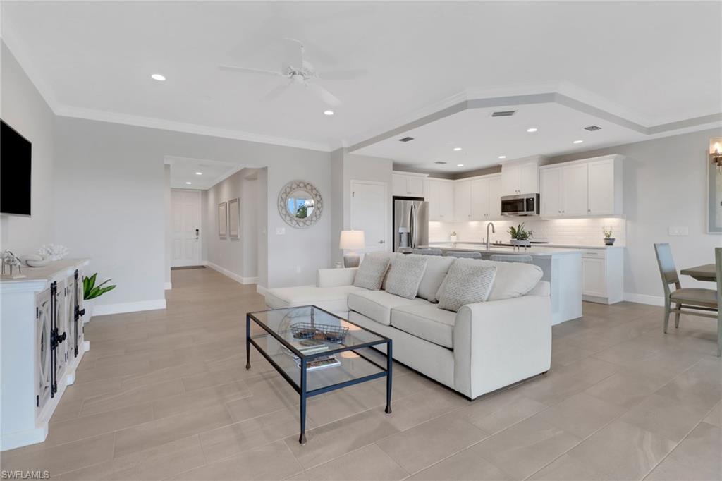 2295 Sawyers Hill Road, Unit 1002 Naples, FL 34120 - Photo 5 of 41 a living room with furniture and a flat screen tv