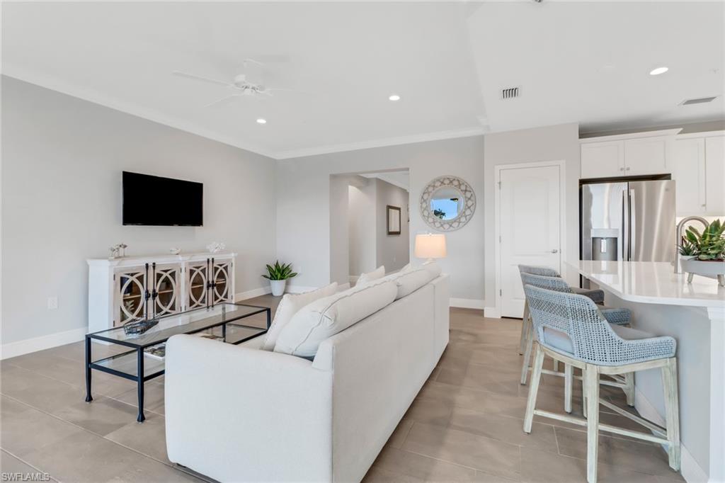2295 Sawyers Hill Road, Unit 1002 Naples, FL 34120 - Photo 6 of 41 a living room with furniture a flat screen tv and a fireplace