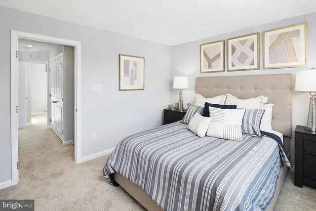 a bedroom with a bed and painting on the wall