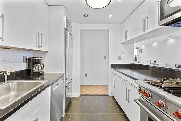 a kitchen with stainless steel appliances granite countertop a sink a stove and a refrigerator