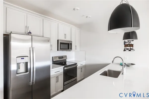 a kitchen with stainless steel appliances a dining table chairs and stove top oven