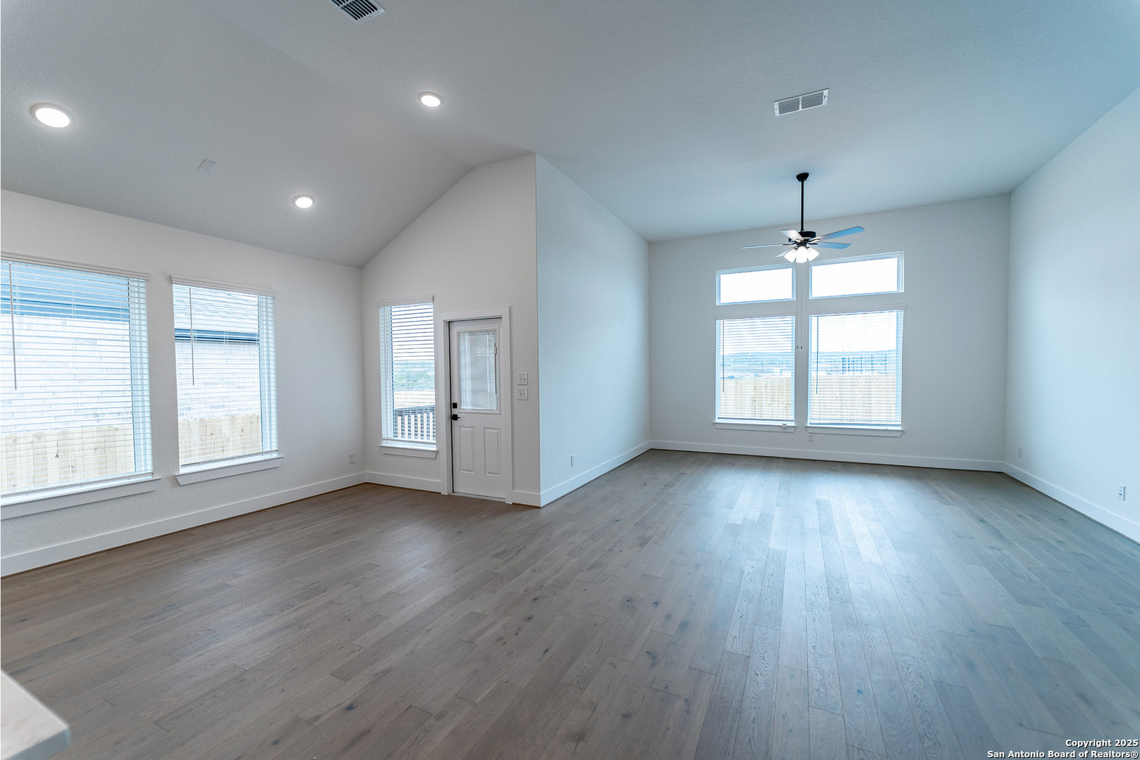 182 Ednie Lane Mico, TX 78056 - Photo 2 of 19 an empty room with wooden floor and windows