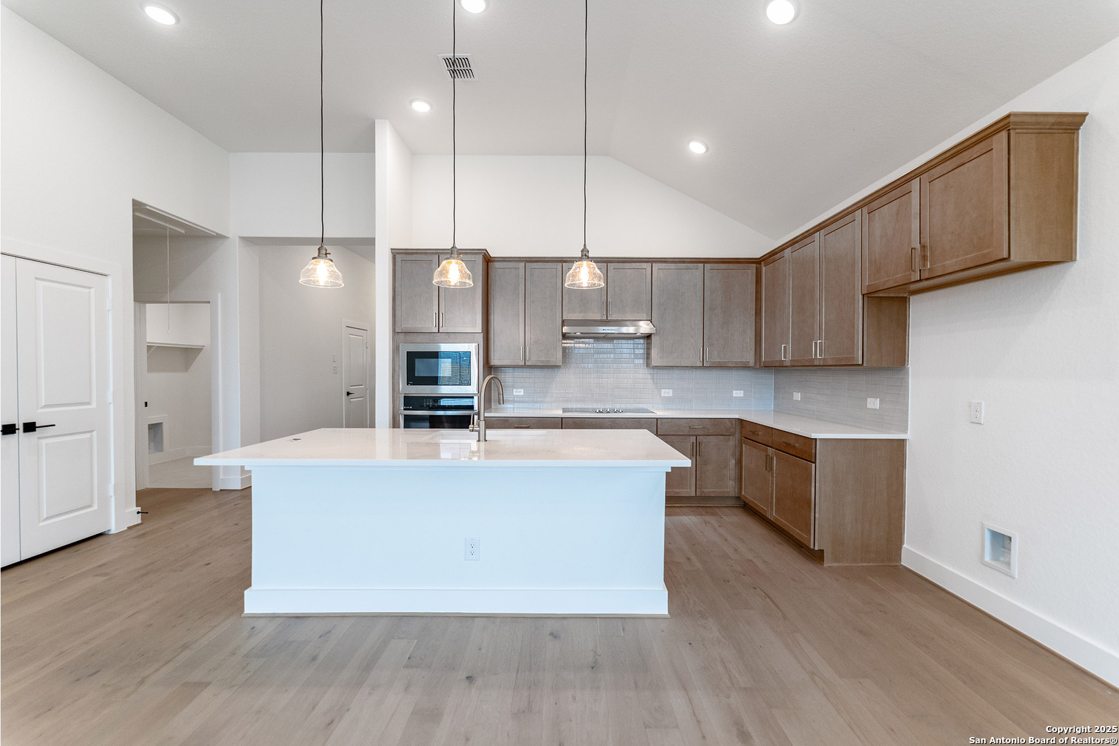 182 Ednie Lane Mico, TX 78056 - Photo 7 of 19 a large kitchen with stainless steel appliances kitchen island a large counter top and a wooden floors