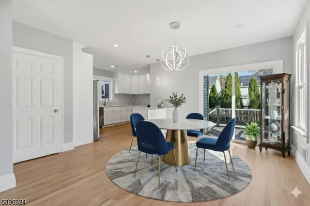 a dining room with furniture a chandelier and wooden floor