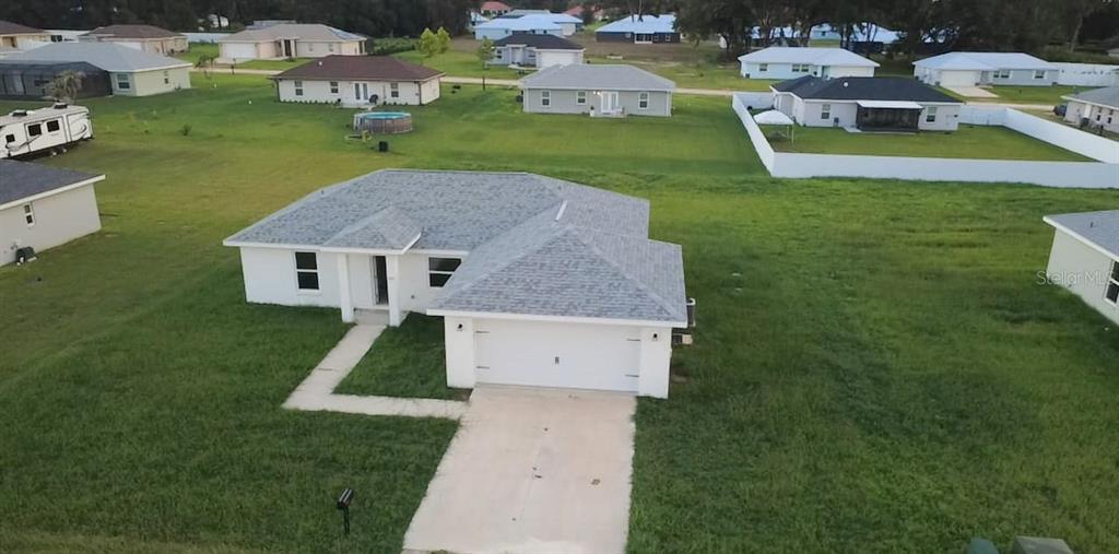 a aerial view of a house with a yard and trees