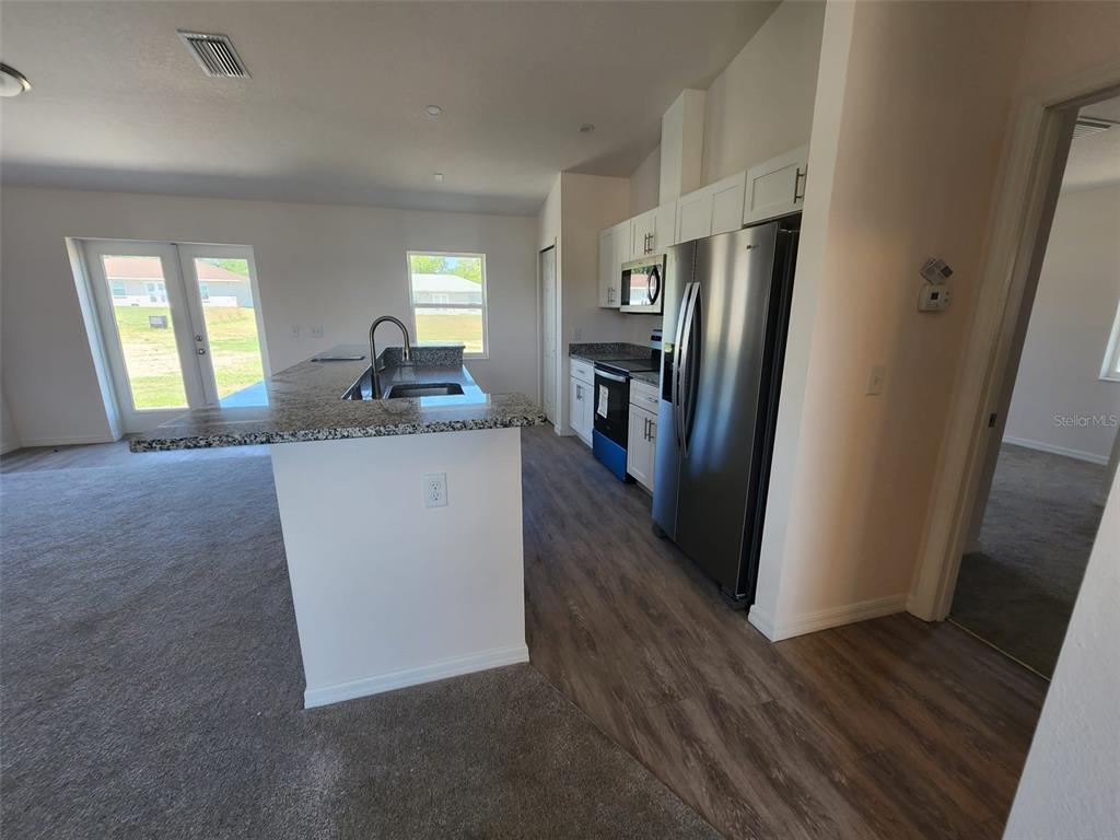 4381 East Ravenna Street Inverness, FL 34453 - Photo 11 of 44 a kitchen with stainless steel appliances granite countertop a refrigerator a stove a sink and dishwasher