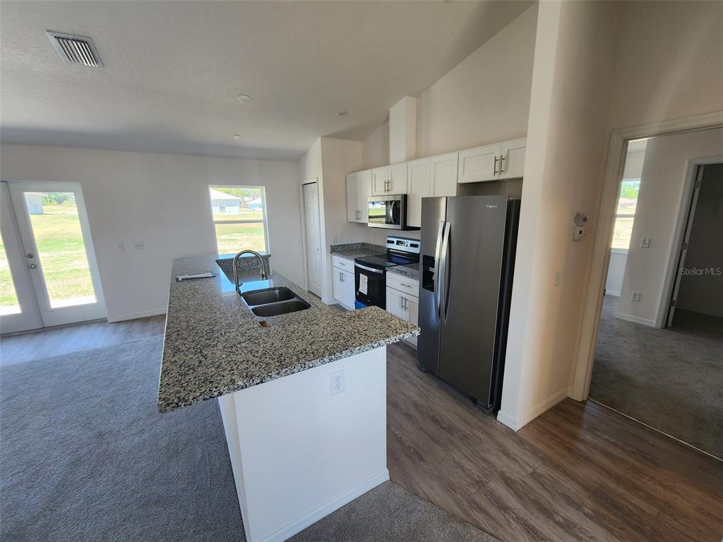 4381 East Ravenna Street Inverness, FL 34453 - Photo 12 of 44 a kitchen with stainless steel appliances granite countertop a refrigerator microwave and stove
