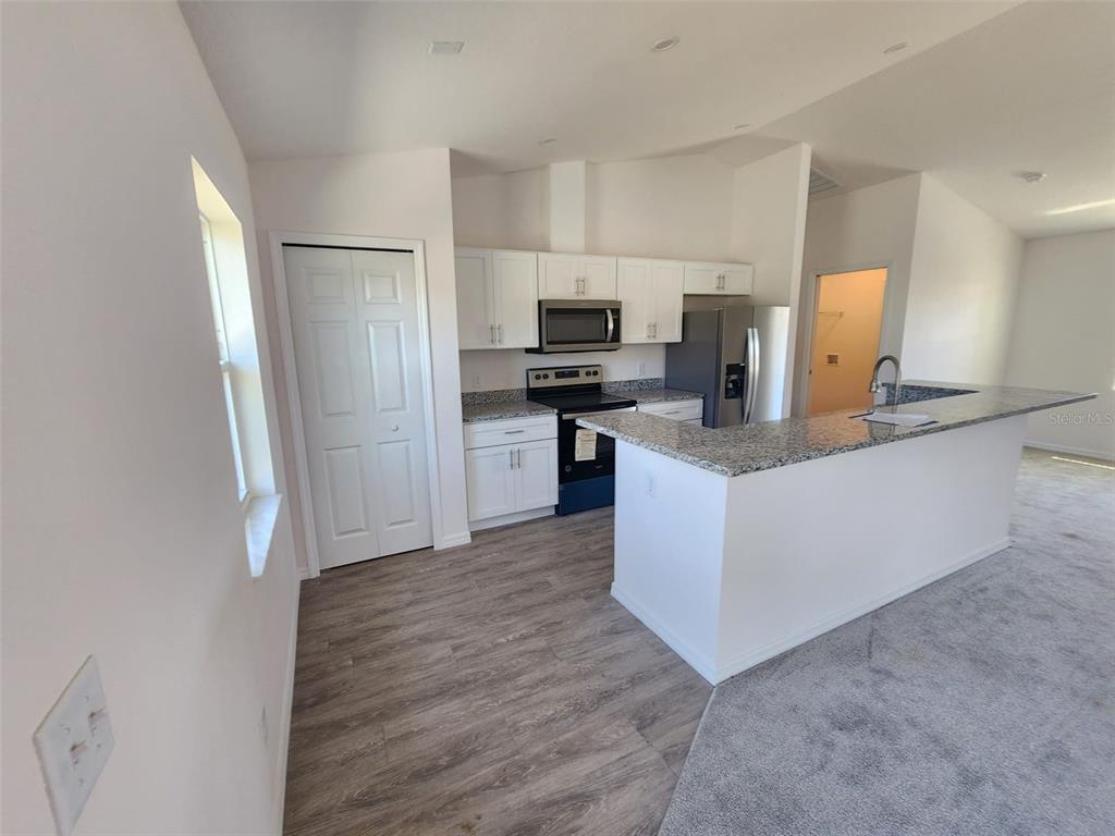 4381 East Ravenna Street Inverness, FL 34453 - Photo 13 of 44 a kitchen with stainless steel appliances a refrigerator and a stove top oven