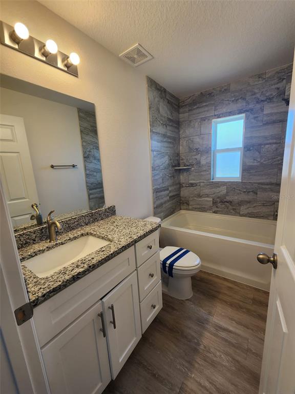 4381 East Ravenna Street Inverness, FL 34453 - Photo 20 of 44 a bathroom with a granite countertop bathtub sink vanity mirror and toilet