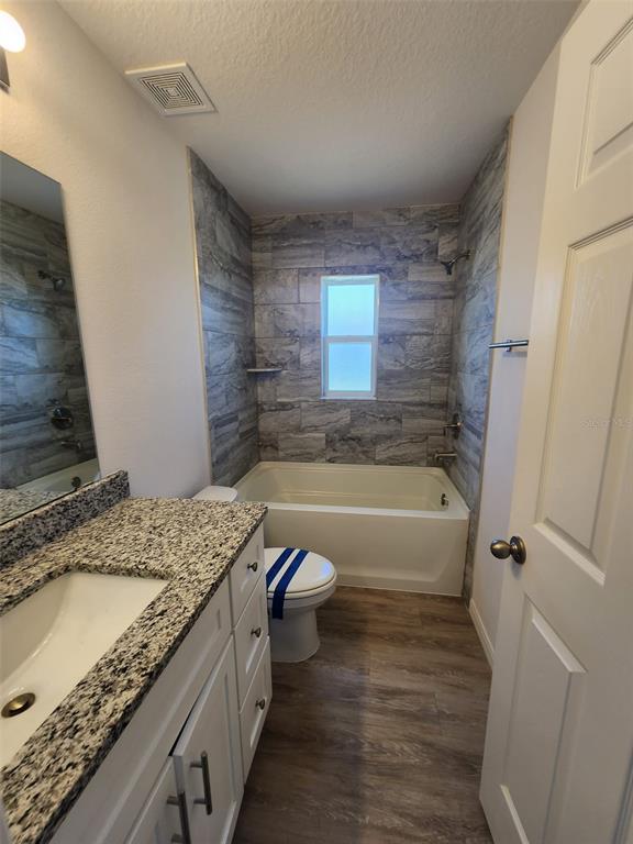 4381 East Ravenna Street Inverness, FL 34453 - Photo 21 of 44 a bathroom with a granite countertop sink a toilet and bathtub