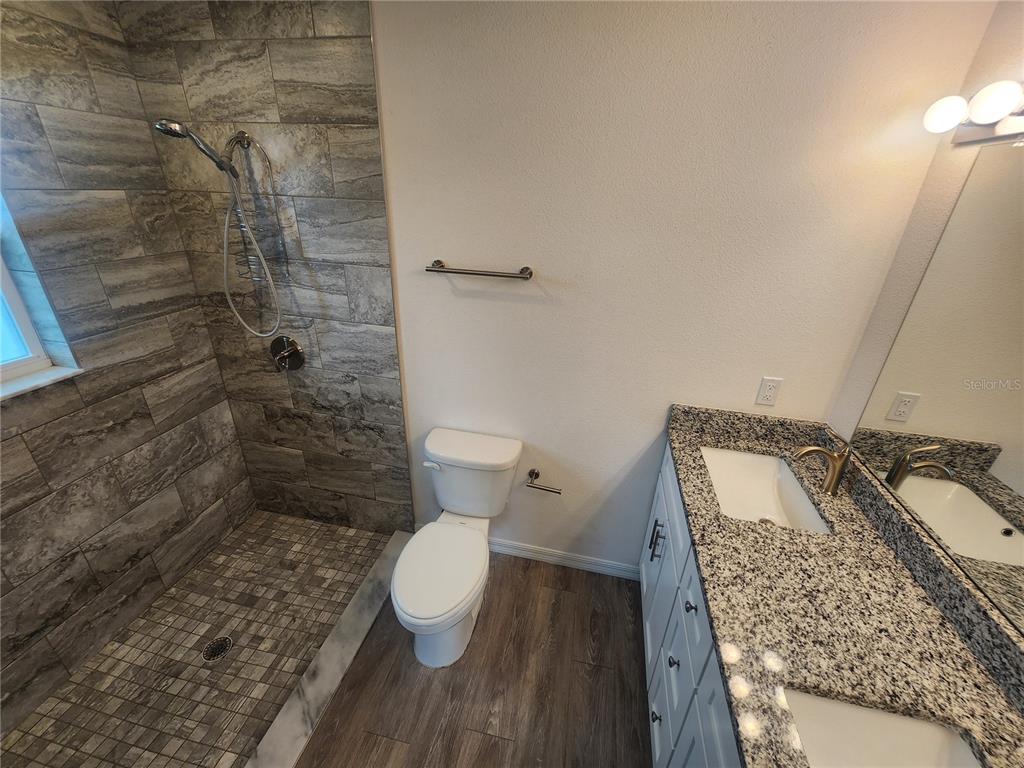 4381 East Ravenna Street Inverness, FL 34453 - Photo 30 of 44 a bathroom with a granite countertop toilet and a sink