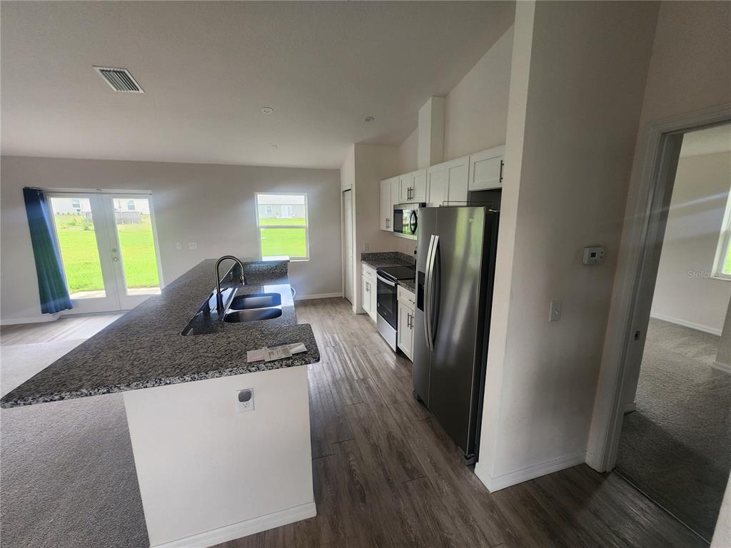 4381 East Ravenna Street Inverness, FL 34453 - Photo 10 of 44 a kitchen with sink refrigerator and window