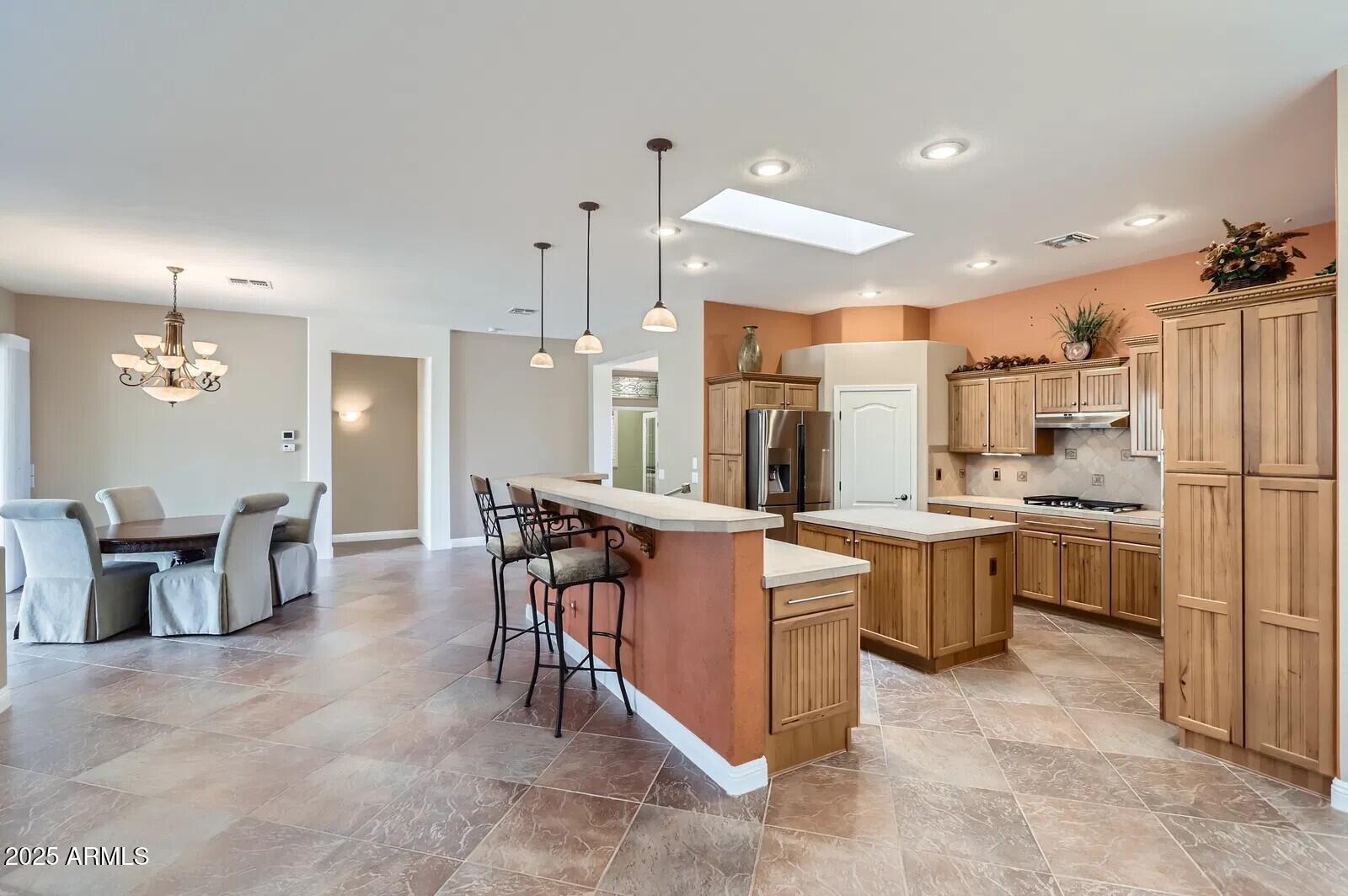 17951 West Sammy Way Surprise, AZ 85374 - Photo 11 of 24 a large kitchen with kitchen island a sink a center island a counter space and stainless steel appliances