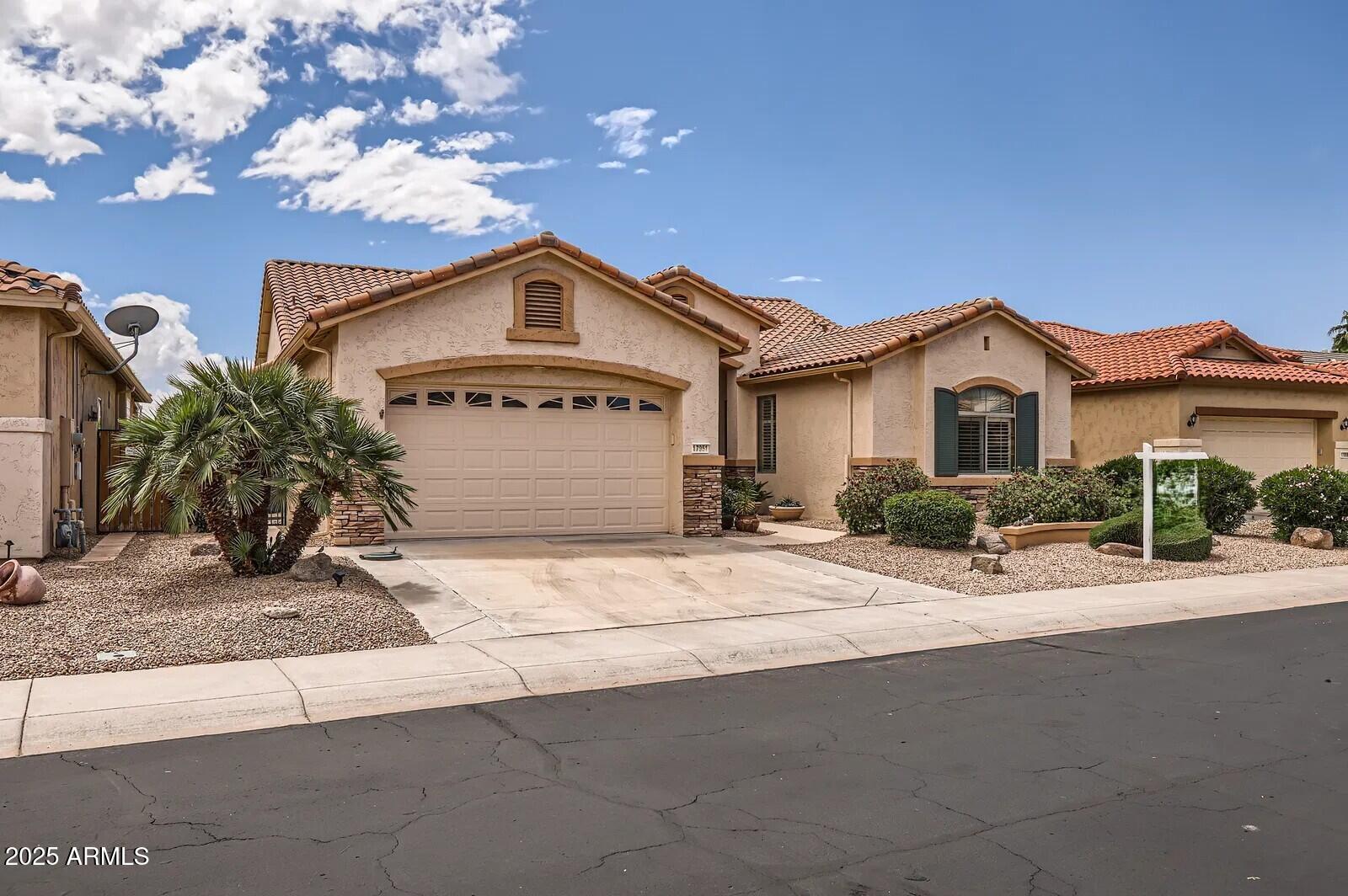 17951 West Sammy Way Surprise, AZ 85374 - Photo 2 of 24 a front view of a house with a yard and garage