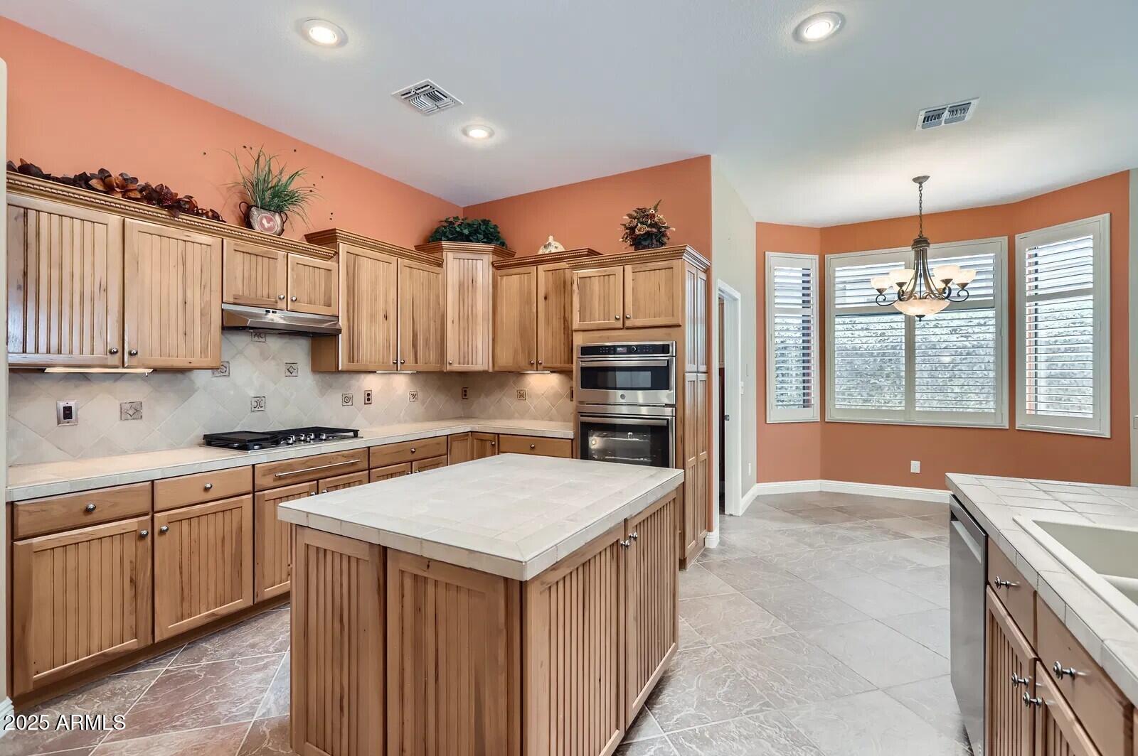 17951 West Sammy Way Surprise, AZ 85374 - Photo 8 of 24 a kitchen with a stove a sink and a refrigerator